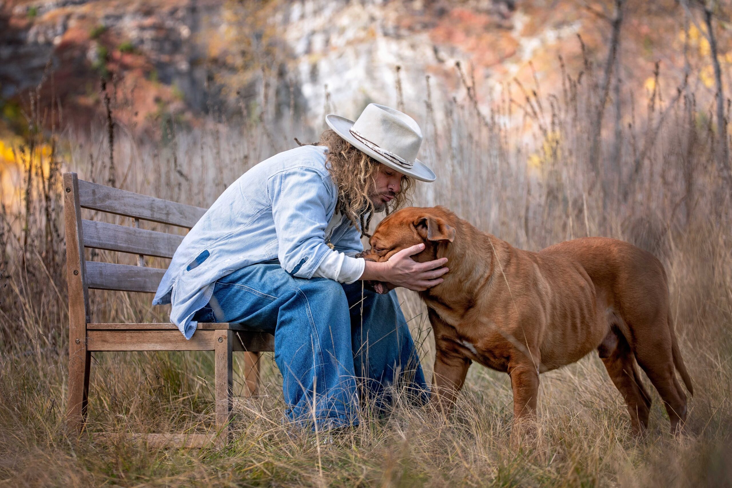 Man with French Mastiff in Fall Seated on Bench