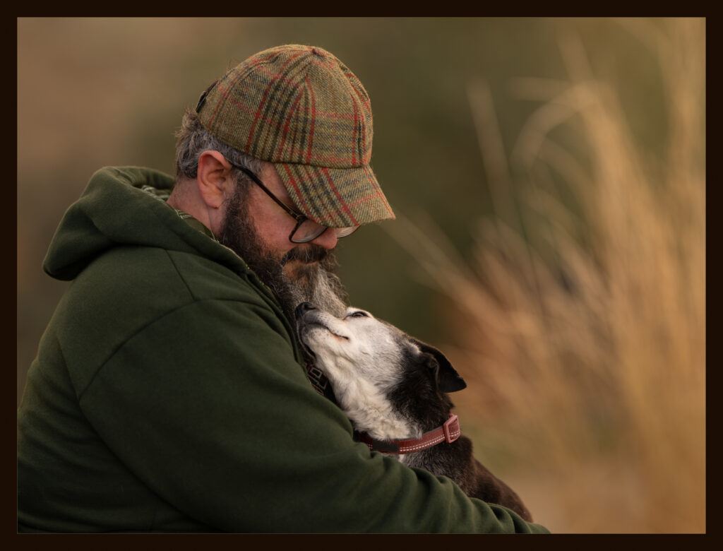 Seated man with senior beagle in his arms gazing into each others' eyes in a fall setting in West Jordan, Utah.