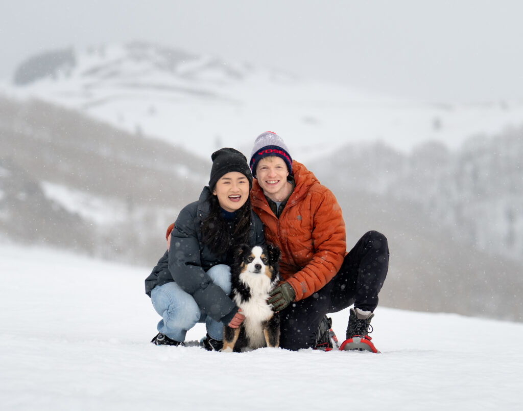 Couple with their dog in a snowstorm at Guardsman Pass above Park City during early spring